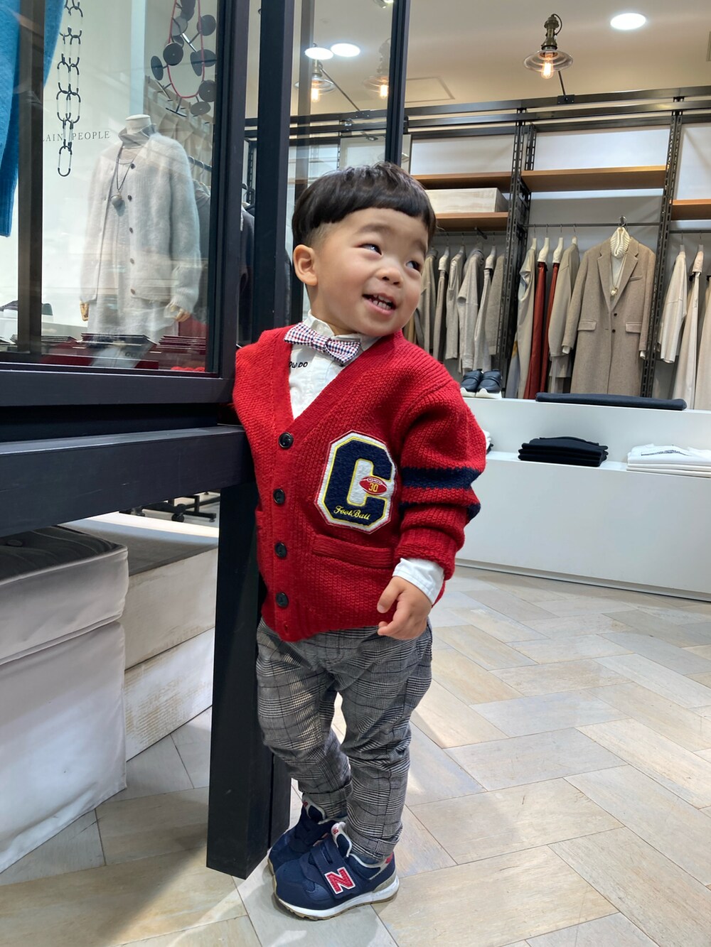 グレー系のパンツ、レッド系のカーディガン/ボレロ、ブルー系のスニーカーを着用したキッズの秋コーディネートの5枚目の写真