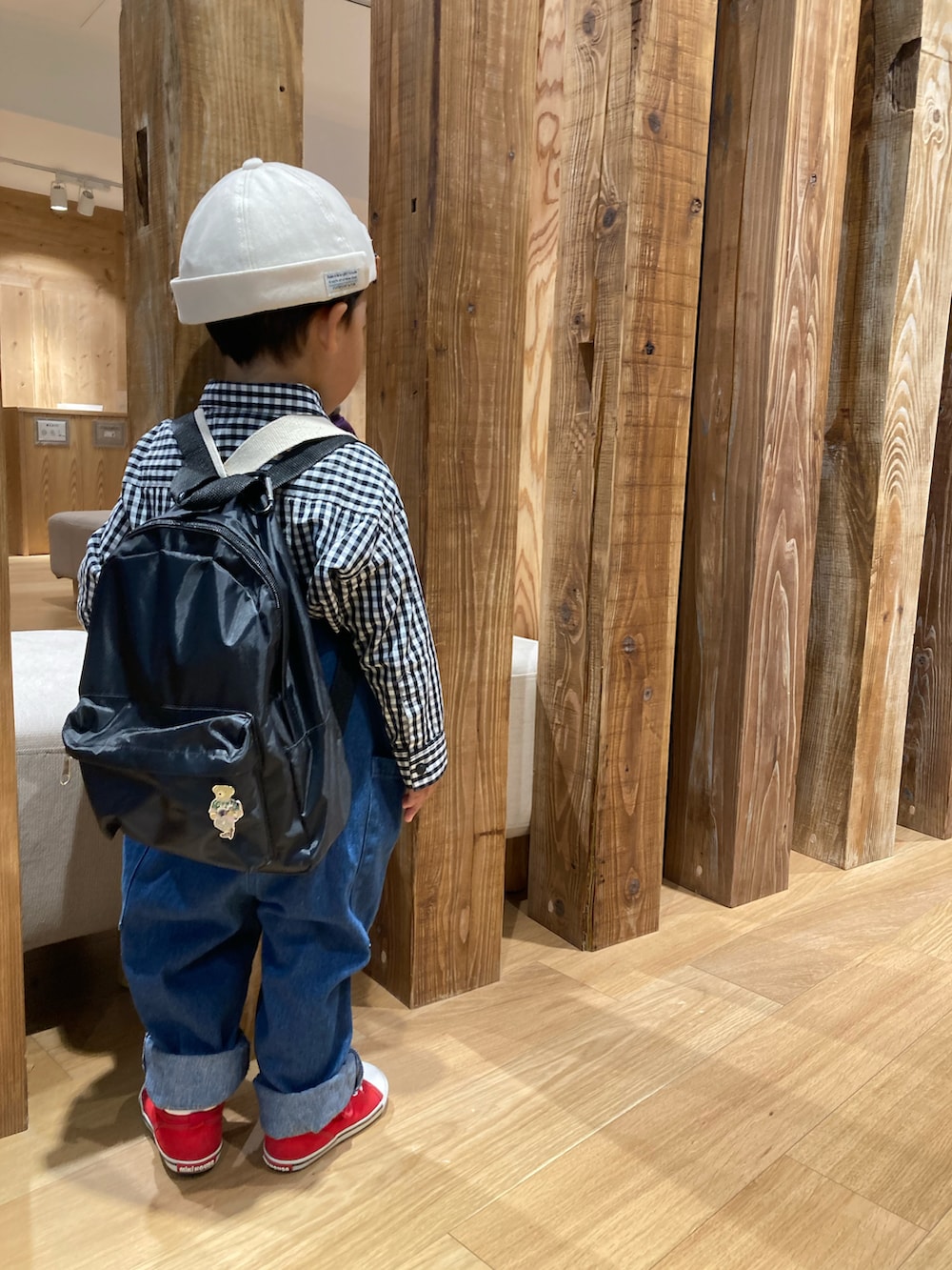 ホワイト系のトップス、ブラック系のトートバッグ、ブルー系のサロペット/オーバーオールを着用したキッズの秋コーディネートの2枚目の写真