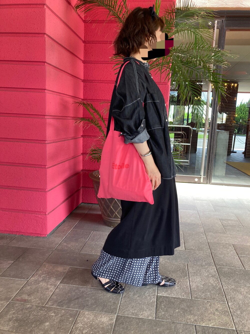 ブラック系のワンピース、ブラック系のサンダル、ピンク系のトートバッグを着用したレディースの秋コーディネートの2枚目の写真
