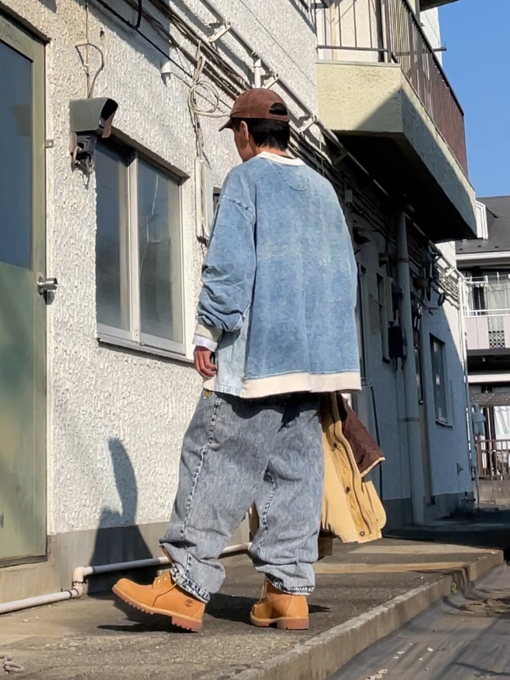 イエロー系のブーツ、ブルー系のデニムパンツ、ブルー系のトップスを着用したメンズの冬コーディネートの2枚目の写真