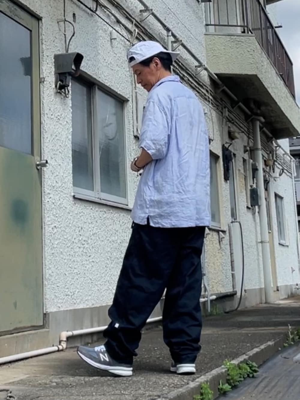 ブルー系のシャツ/ブラウス、ブルー系のチノパンツ、グレー系のスニーカーを着用したメンズの夏コーディネートの2枚目の写真