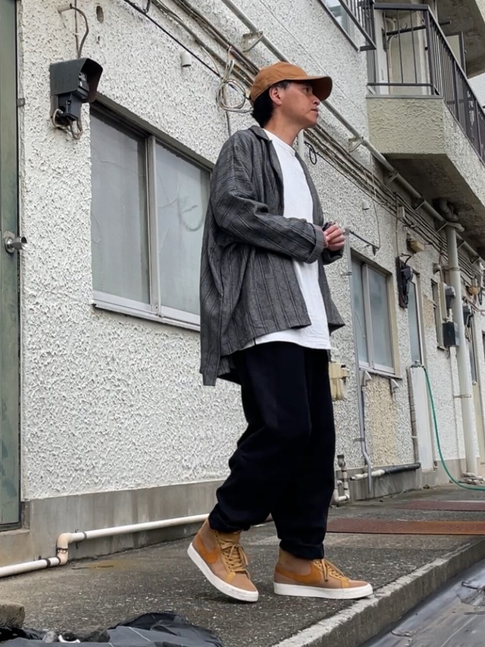 ブラウン系のスニーカー、ブラック系のその他パンツ、ホワイト系のTシャツ/カットソーを着用したメンズの秋コーディネートの2枚目の写真