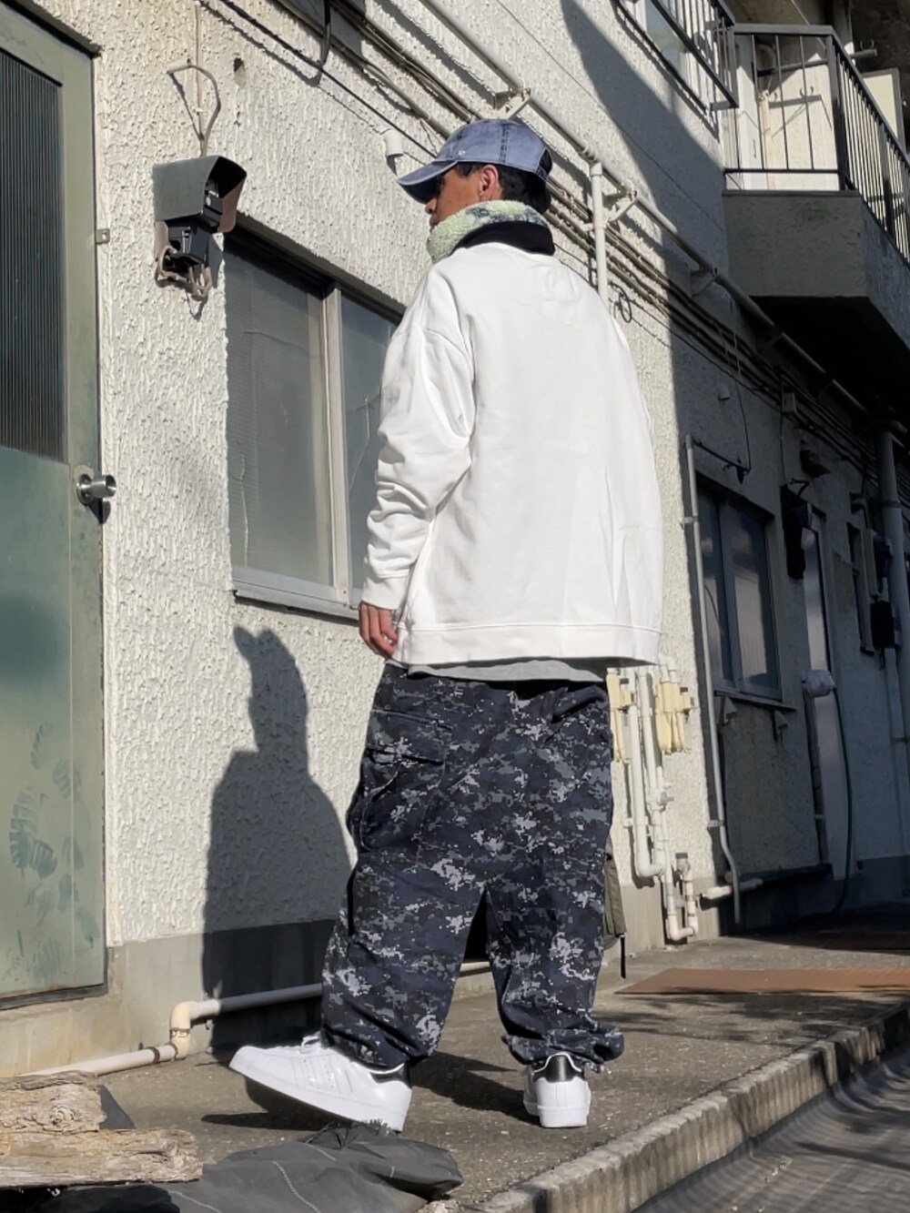 ホワイト系のスニーカー、ブルー系のその他パンツ、ホワイト系のスウェットを着用したメンズの冬コーディネートの2枚目の写真