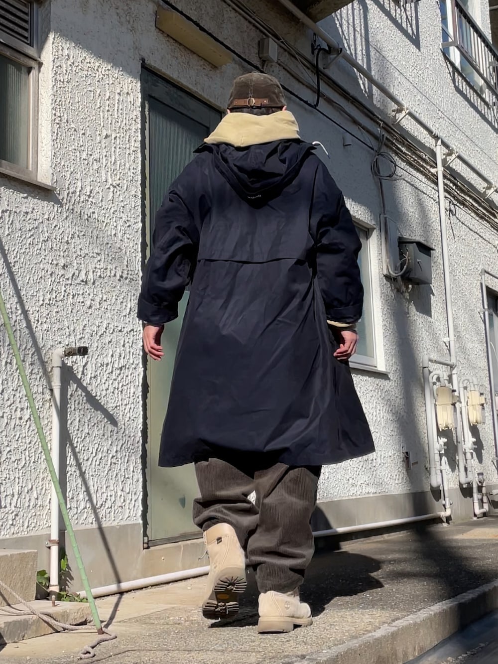 ベージュ系のブーツ、グリーン系のその他パンツ、ブルー系のステンカラーコートを着用したメンズの冬コーディネートの2枚目の写真