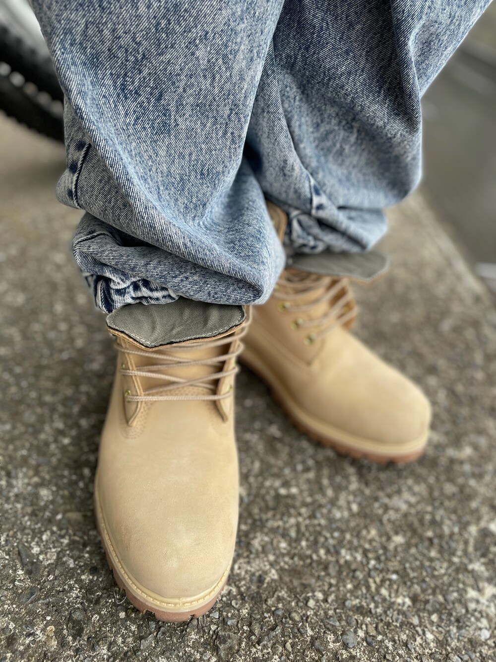 ベージュ系のブーツ、ブルー系のデニムパンツ、ブルー系のポロシャツを着用したメンズの春コーディネートの3枚目の写真