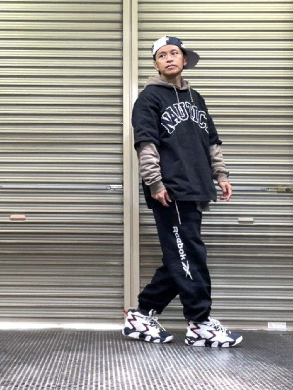 ホワイト系のスニーカー、ブラック系のスウェットパンツ、ブラック系のTシャツ/カットソーを着用したメンズの冬コーディネートの2枚目の写真