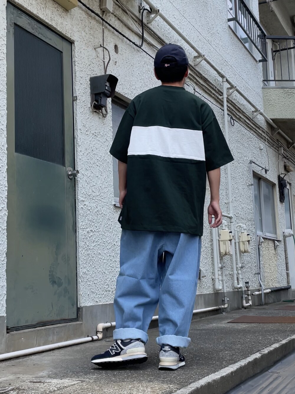 ブルー系のスニーカー、ブルー系のデニムパンツ、グリーン系のTシャツ/カットソーを着用したメンズの夏コーディネートの2枚目の写真