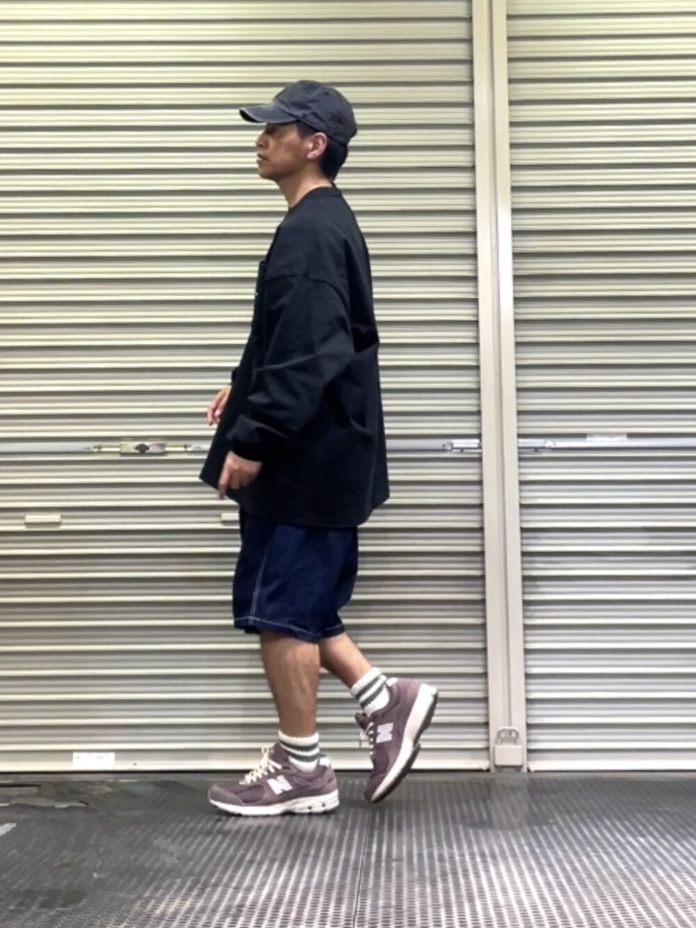 ブラウン系のスニーカー、ブルー系のデニムパンツ、ブラック系のTシャツ/カットソーを着用したメンズの春コーディネートの2枚目の写真