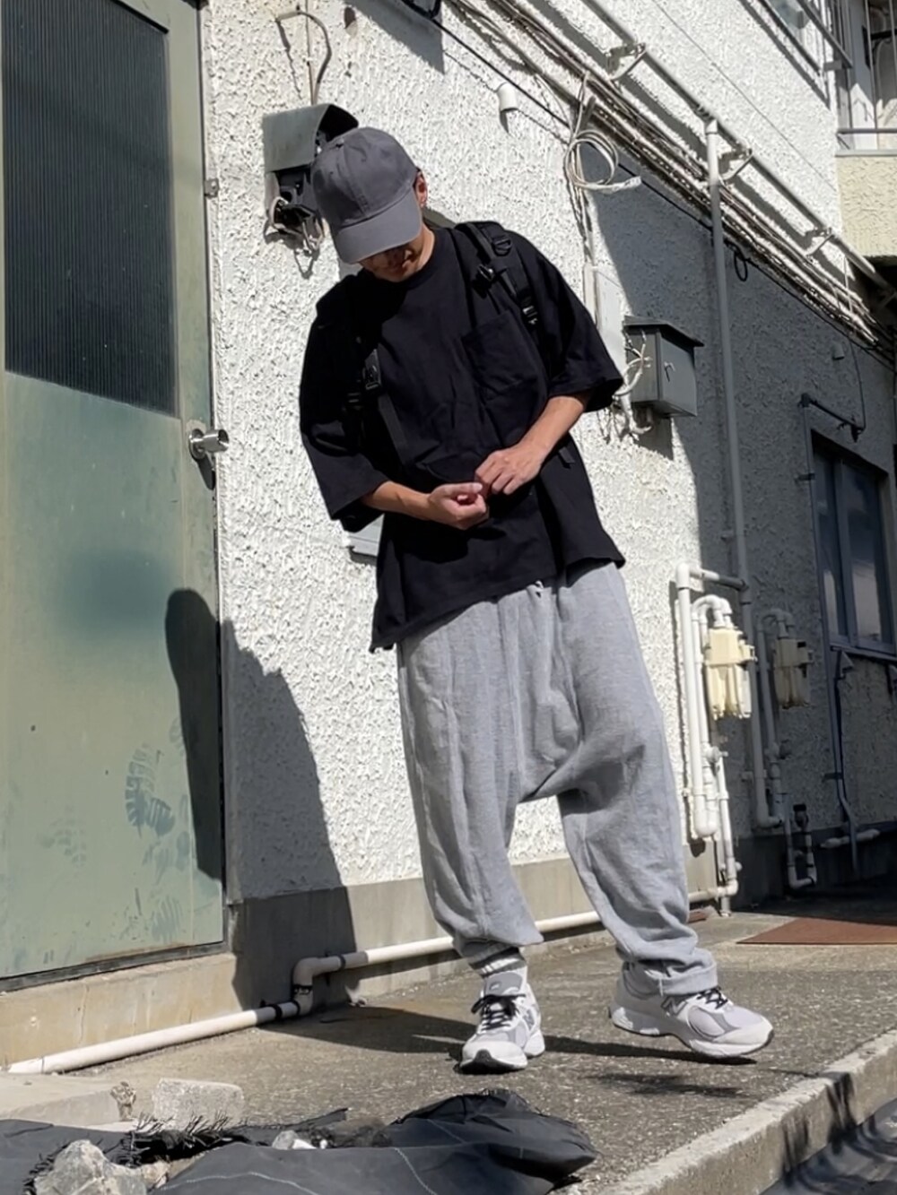 グレー系のスニーカー、グレー系のその他パンツ、ブラック系のTシャツ/カットソーを着用したメンズの秋コーディネートの3枚目の写真