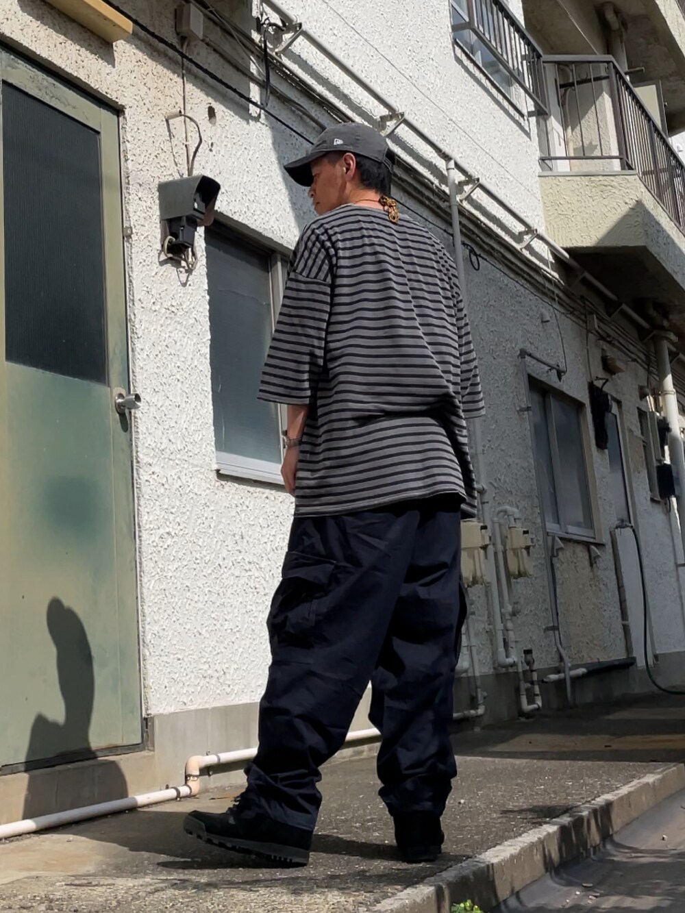 ブラック系のスニーカー、ブルー系のその他パンツ、グレー系のTシャツ/カットソーを着用したメンズの夏コーディネートの2枚目の写真