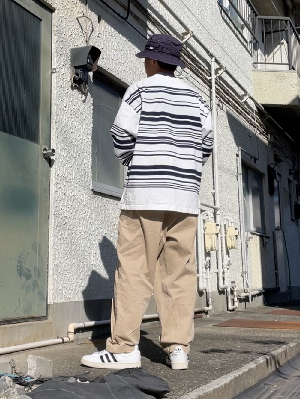 ホワイト系のスニーカー、ベージュ系のその他パンツ、ホワイト系のTシャツ/カットソーを着用したメンズの秋コーディネートの2枚目の写真