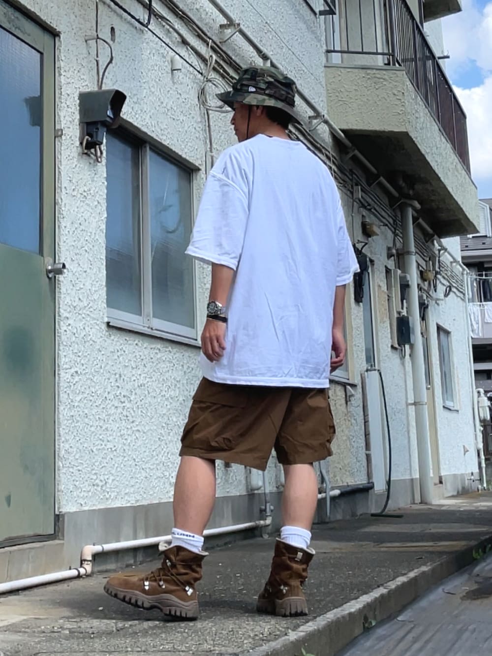 ホワイト系のTシャツ/カットソー、ブラウン系のカーゴパンツ、ブラウン系のブーツを着用したメンズの夏コーディネートの2枚目の写真