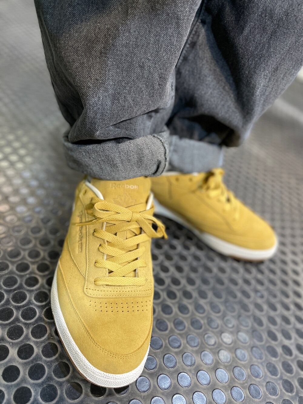 ベージュ系のスニーカー、ブラック系のデニムパンツ、グリーン系のポロシャツを着用したメンズの秋コーディネートの4枚目の写真