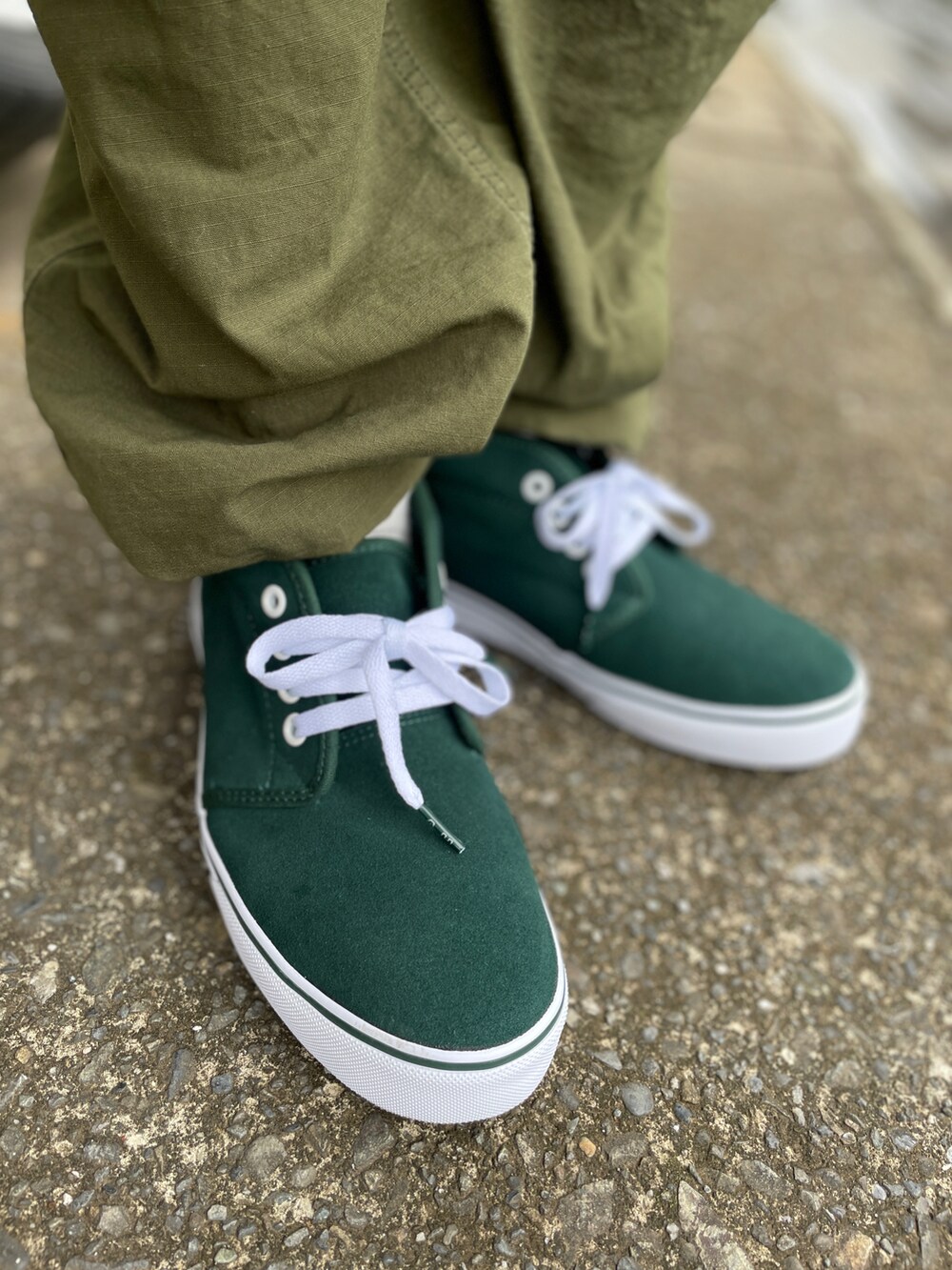 グリーン系のスニーカー、グリーン系のカーゴパンツ、ベージュ系のベストを着用したメンズの夏コーディネートの3枚目の写真