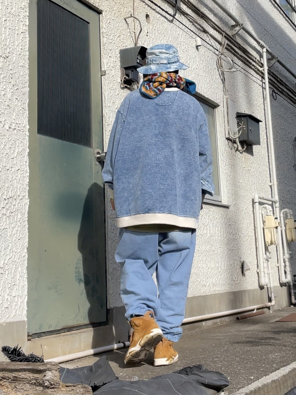 ブラウン系のスニーカー、ブルー系のデニムパンツ、ブルー系のトップスを着用したメンズの春コーディネートの2枚目の写真