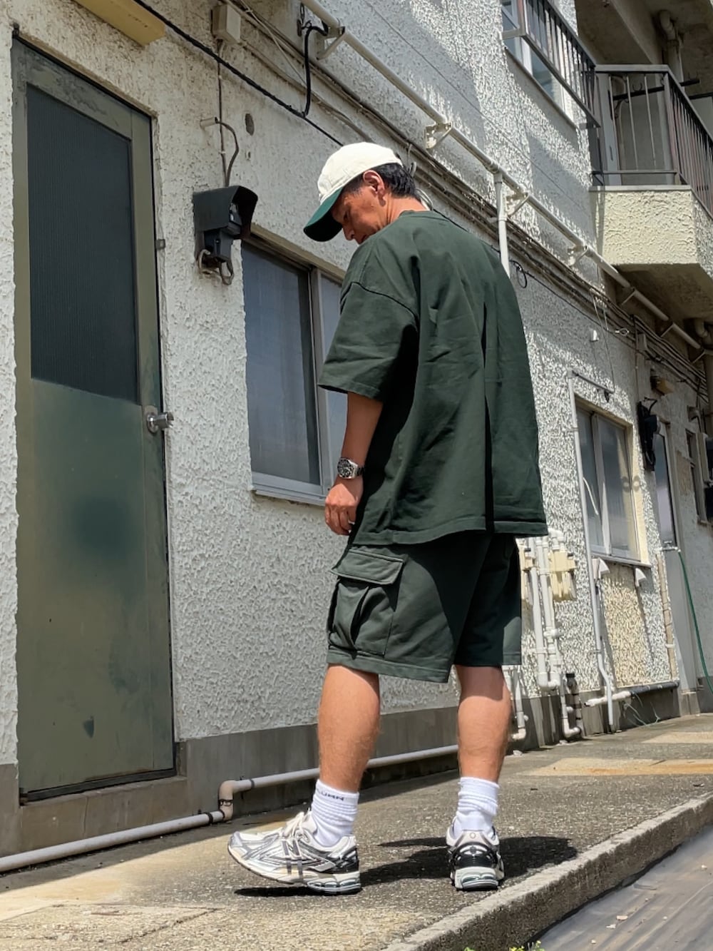 ホワイト系のスニーカー、グリーン系のカーゴパンツ、グリーン系のTシャツ/カットソーを着用したメンズの夏コーディネートの2枚目の写真