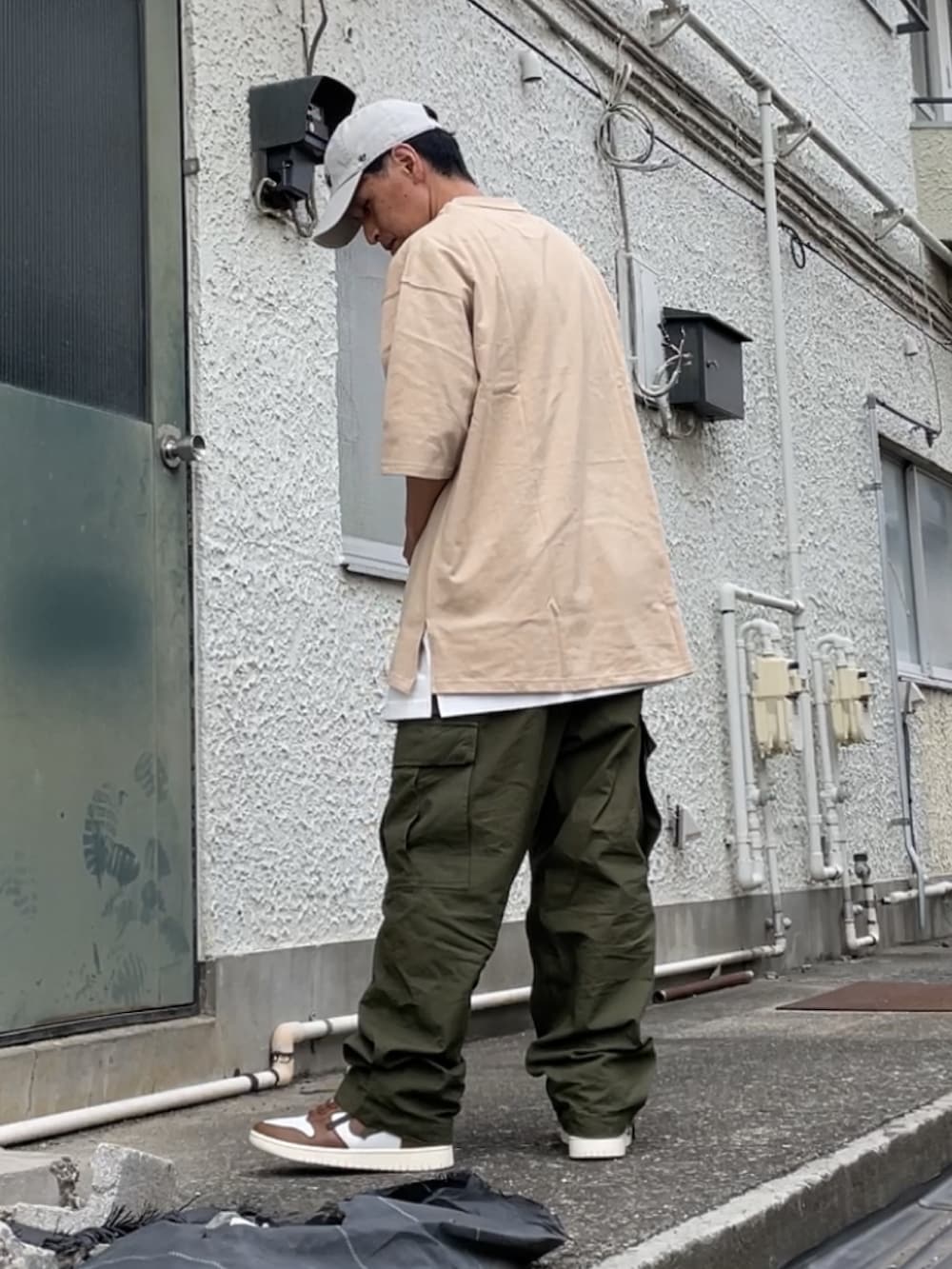 ブラウン系のスニーカー、グリーン系のカーゴパンツ、ホワイト系のTシャツ/カットソーを着用したメンズの夏コーディネートの2枚目の写真
