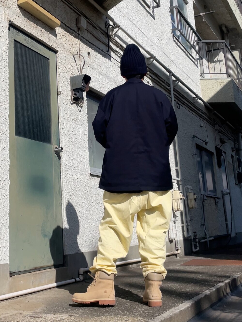 ベージュ系のブーツ、イエロー系のその他パンツ、ブルー系のテーラードジャケットを着用したメンズの春コーディネートの2枚目の写真