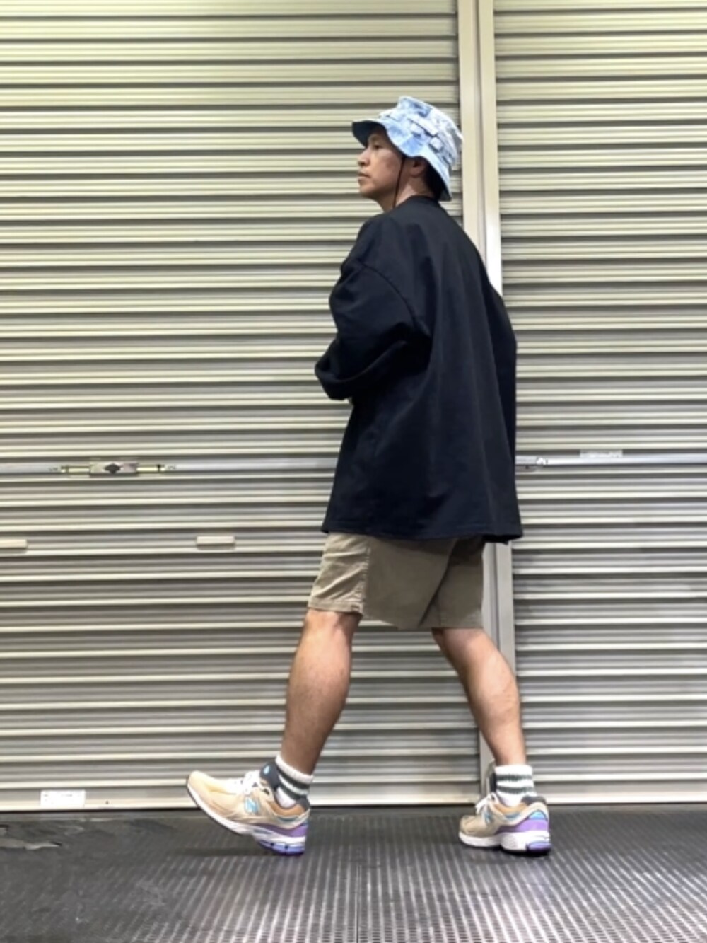 ベージュ系のスニーカー、ブラック系のTシャツ/カットソー、ブルー系のハットを着用したメンズの春コーディネートの2枚目の写真