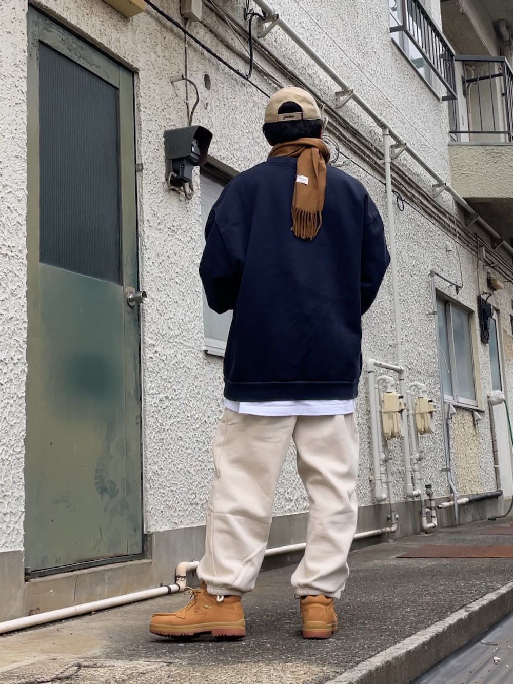 イエロー系のブーツ、ホワイト系のスウェットパンツ、ブルー系のスウェットを着用したメンズの冬コーディネートの2枚目の写真