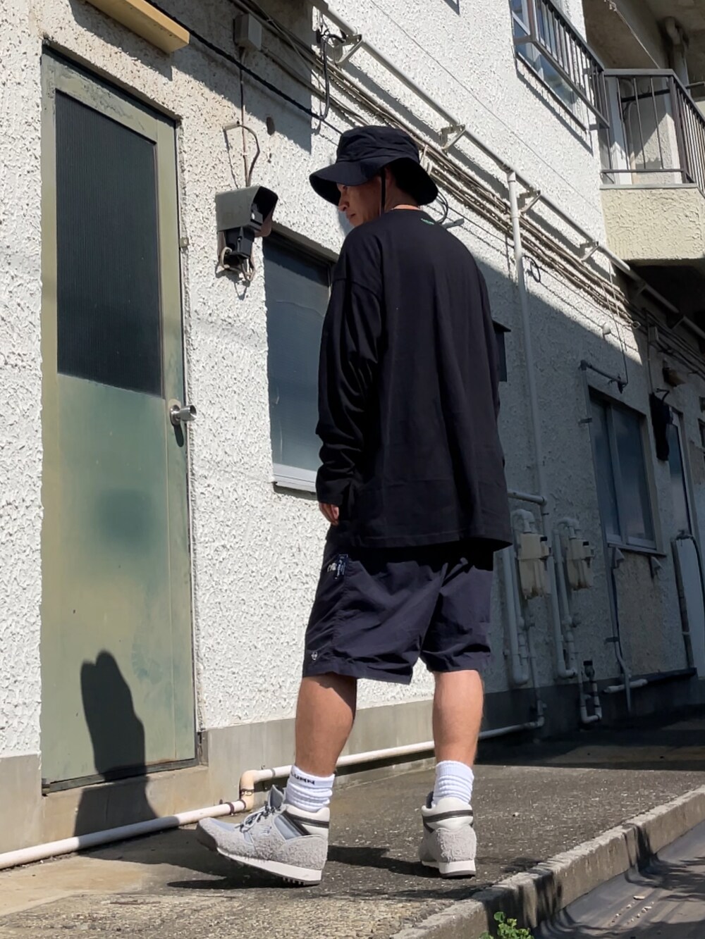グレー系のブーツ、ブルー系のその他パンツ、ブラック系のTシャツ/カットソーを着用したメンズの夏コーディネートの2枚目の写真