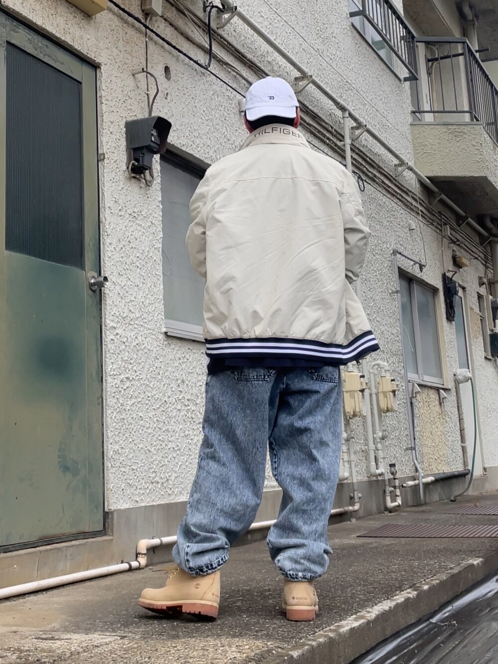 ベージュ系のブーツ、ブルー系のデニムパンツ、ブルー系のポロシャツを着用したメンズの春コーディネートの2枚目の写真