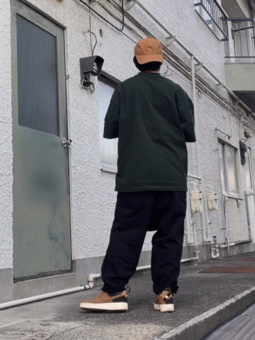 ブラウン系のスニーカー、ブラック系のその他パンツ、グリーン系のTシャツ/カットソーを着用したメンズの秋コーディネートの2枚目の写真