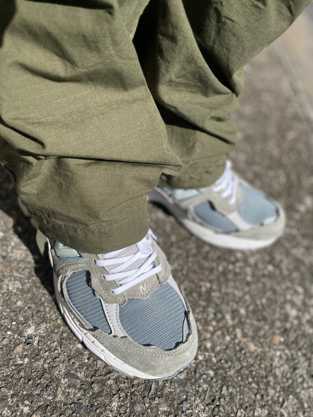 グレー系のスニーカー、グリーン系のカーゴパンツ、グレー系のTシャツ/カットソーを着用したメンズの秋コーディネートの3枚目の写真