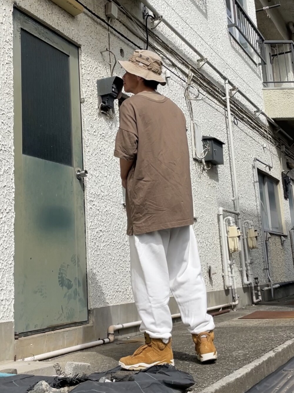 ブラウン系のスニーカー、ホワイト系のその他パンツ、グリーン系のTシャツ/カットソーを着用したメンズの秋コーディネートの2枚目の写真