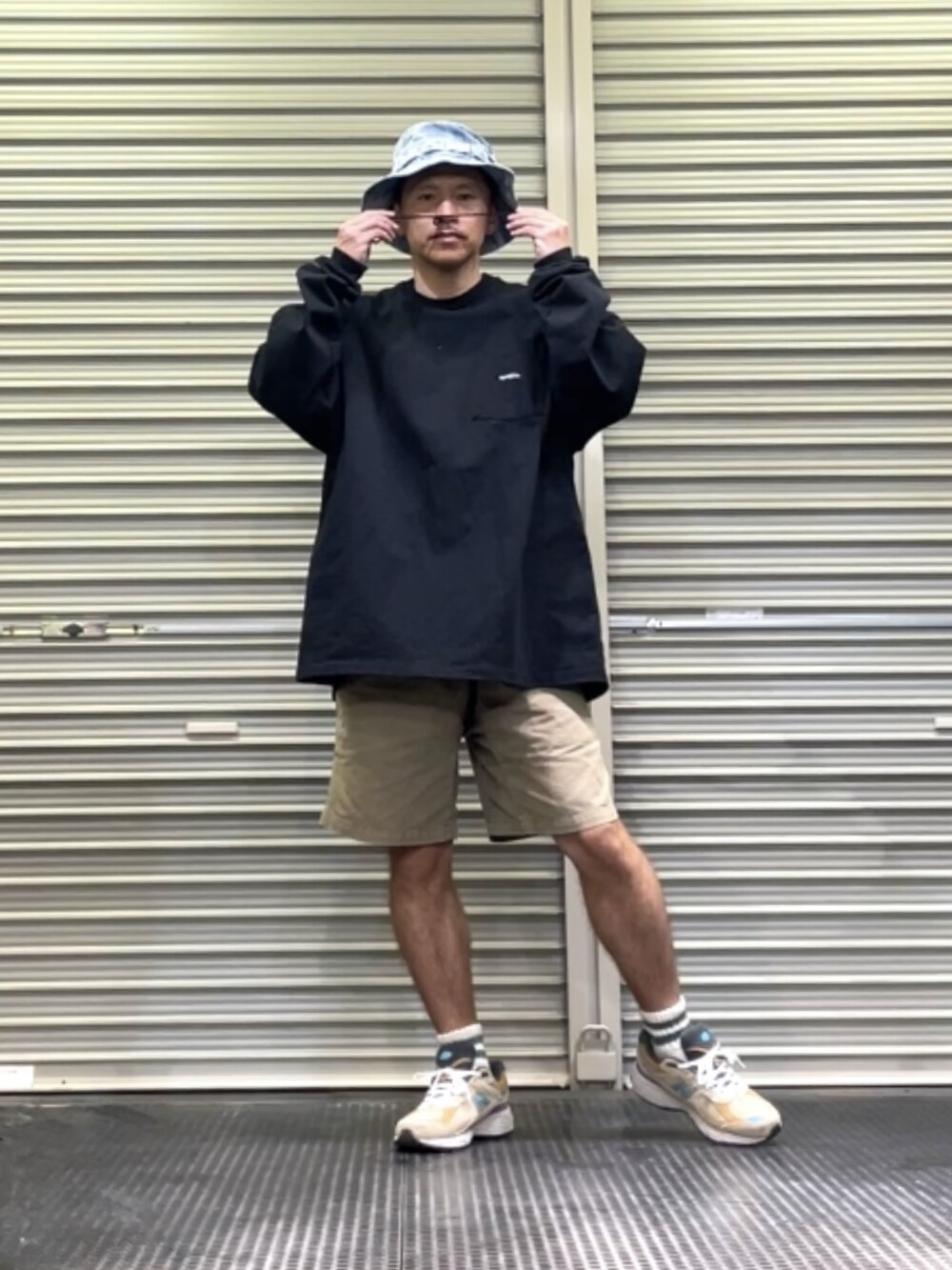 ベージュ系のスニーカー、ブラック系のTシャツ/カットソー、ブルー系のハットを着用したメンズの春コーディネートの4枚目の写真