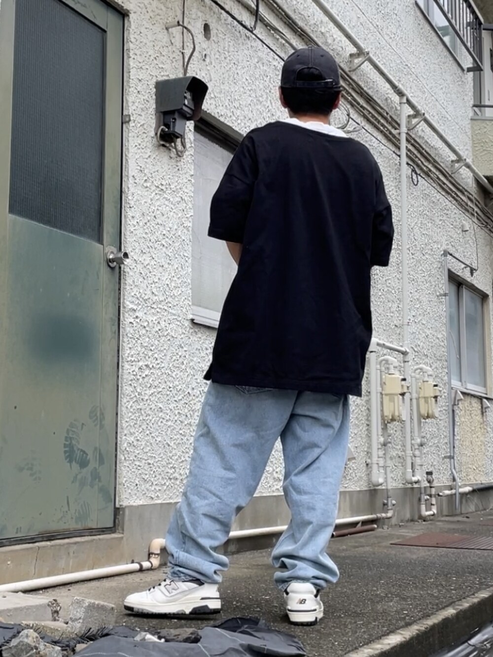 ホワイト系のスニーカー、ブルー系のデニムパンツ、ブラック系のTシャツ/カットソーを着用したメンズの秋コーディネートの2枚目の写真