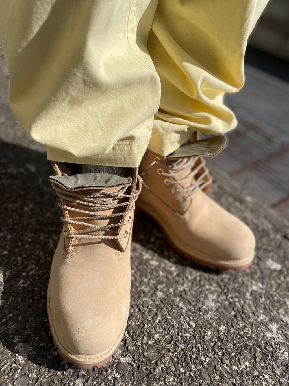 ベージュ系のブーツ、イエロー系のその他パンツ、ブルー系のTシャツ/カットソーを着用したメンズの春コーディネートの3枚目の写真