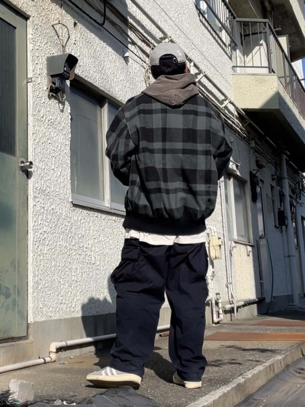 グレー系のスニーカー、ブルー系のカーゴパンツ、ブラウン系のパーカーを着用したメンズの秋コーディネートの2枚目の写真