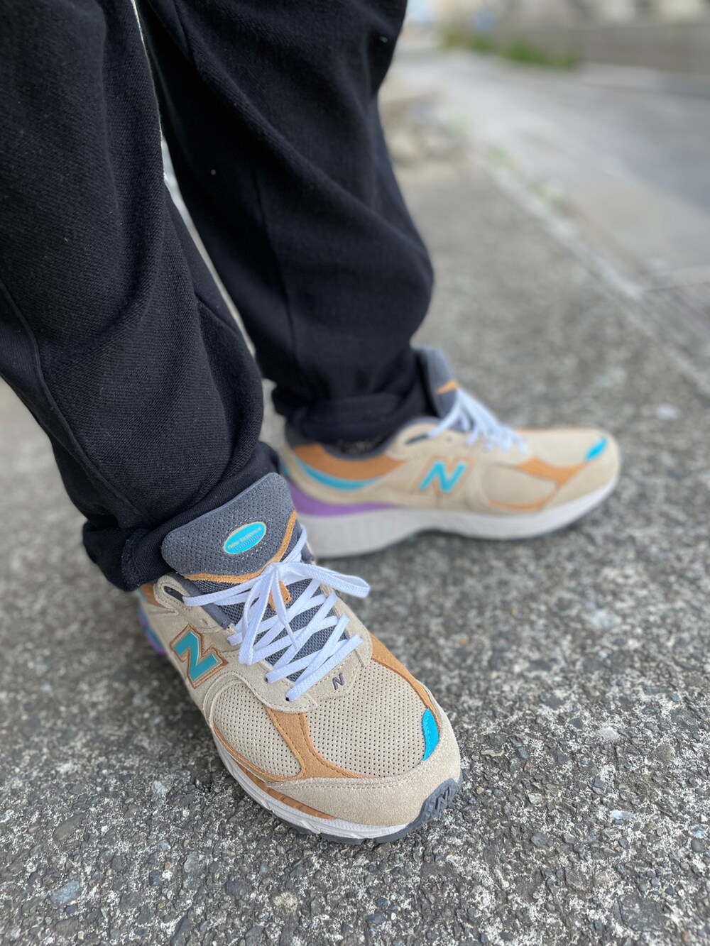 ベージュ系のスニーカー、ブラック系のその他パンツ、ブルー系のTシャツ/カットソーを着用したメンズの春コーディネートの3枚目の写真