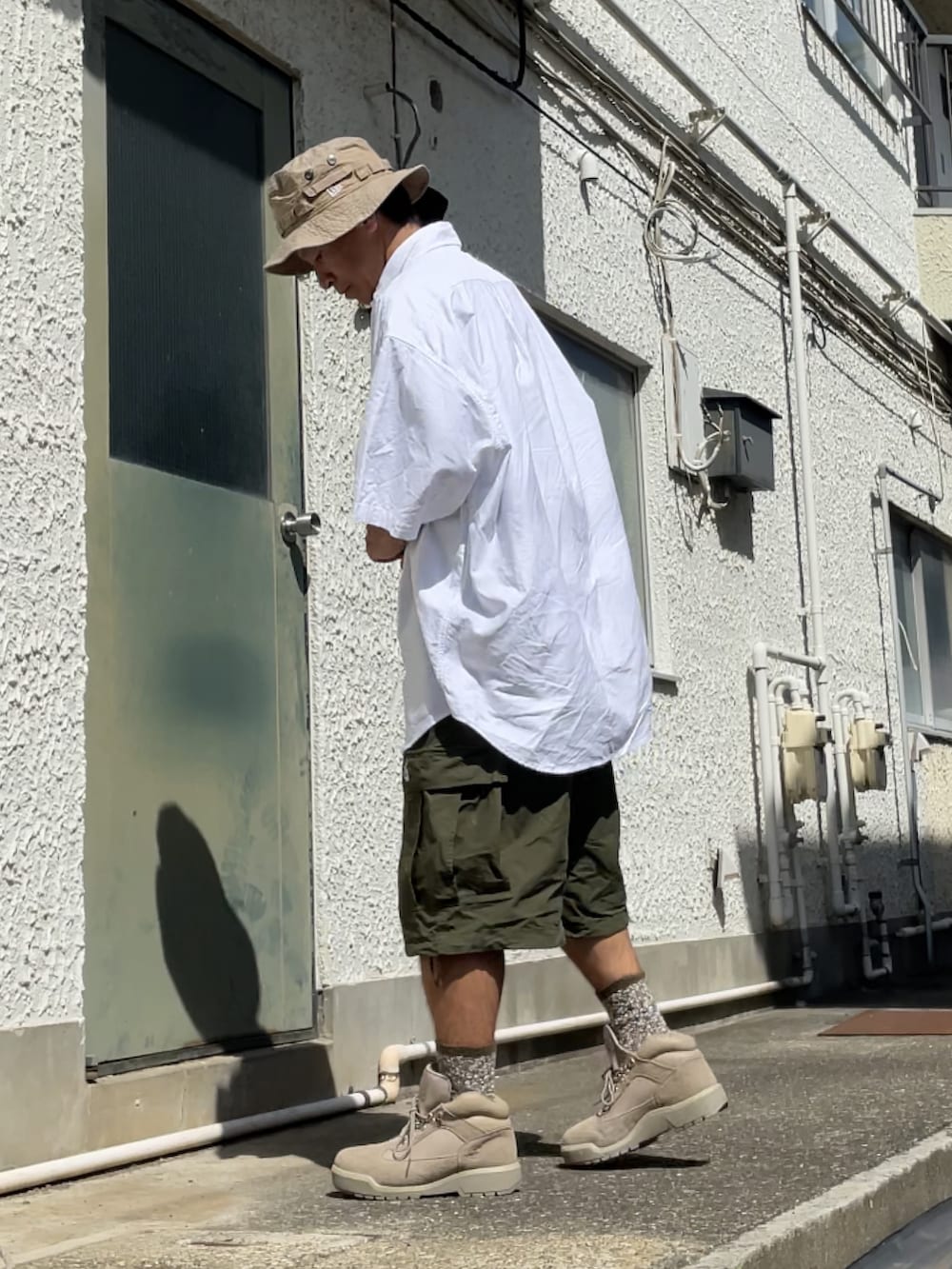 ベージュ系のブーツ、グリーン系のカーゴパンツ、ホワイト系のシャツ/ブラウスを着用したメンズの秋コーディネートの2枚目の写真