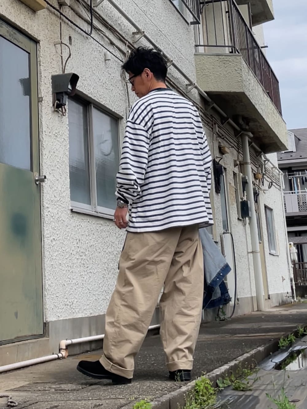ベージュ系のチノパンツ、ブラック系のブーツ、ブルー系のTシャツ/カットソーを着用したメンズの春コーディネートの2枚目の写真