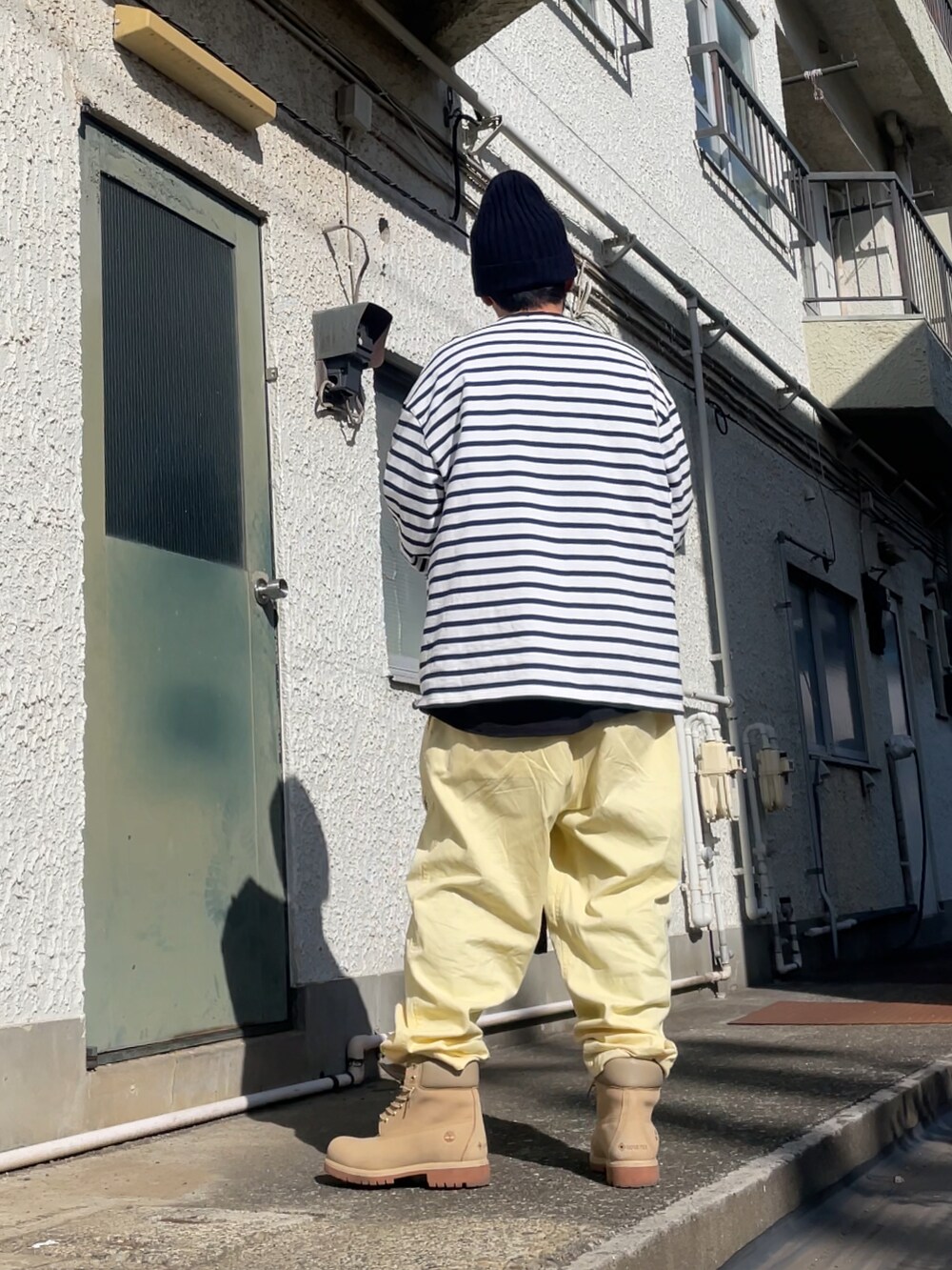 ベージュ系のブーツ、イエロー系のその他パンツ、ブルー系のTシャツ/カットソーを着用したメンズの春コーディネートの2枚目の写真