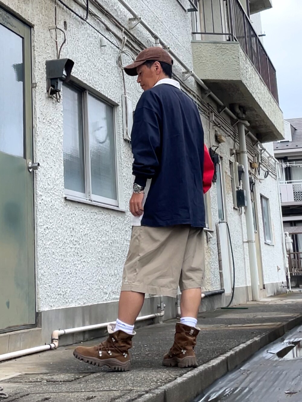 ブルー系のポロシャツ、ベージュ系のチノパンツ、ブラウン系のブーツを着用したメンズの秋コーディネートの2枚目の写真