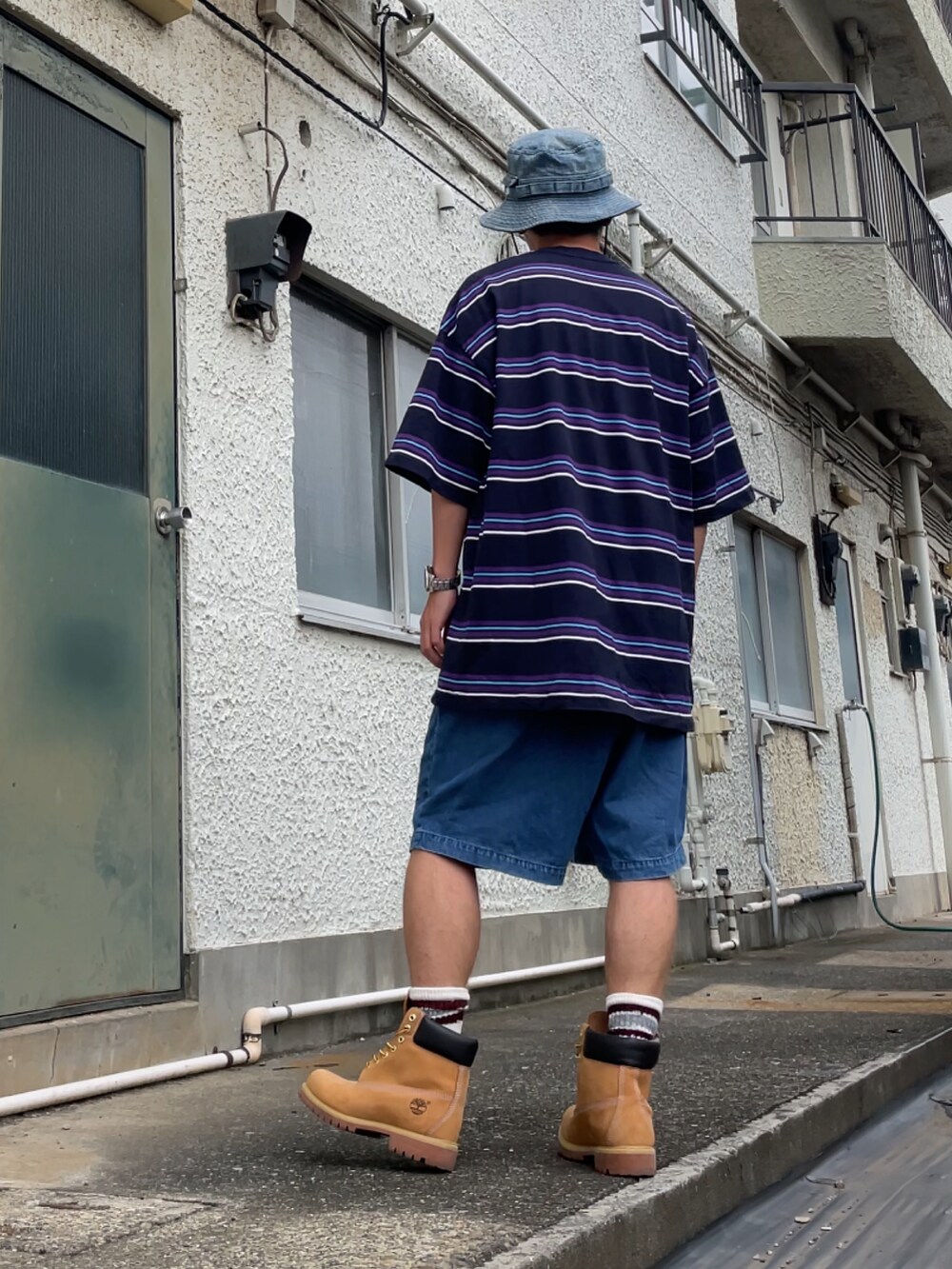 イエロー系のブーツ、ブルー系のその他パンツ、ブルー系のTシャツ/カットソーを着用したメンズの夏コーディネートの2枚目の写真