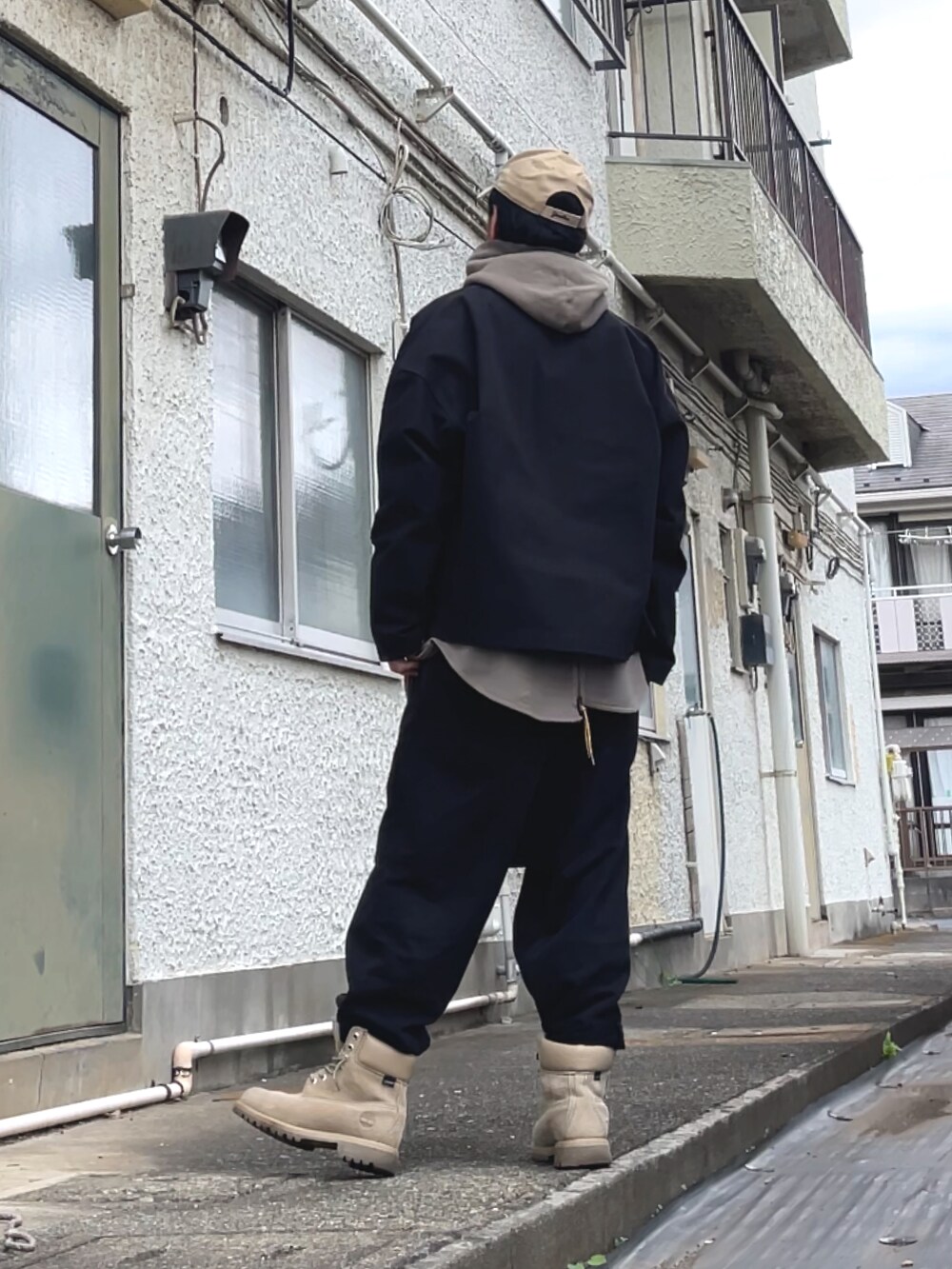 ブラック系のその他パンツ、ベージュ系のパーカー、ブラック系のジャケット/アウターを着用したメンズの秋コーディネートの2枚目の写真