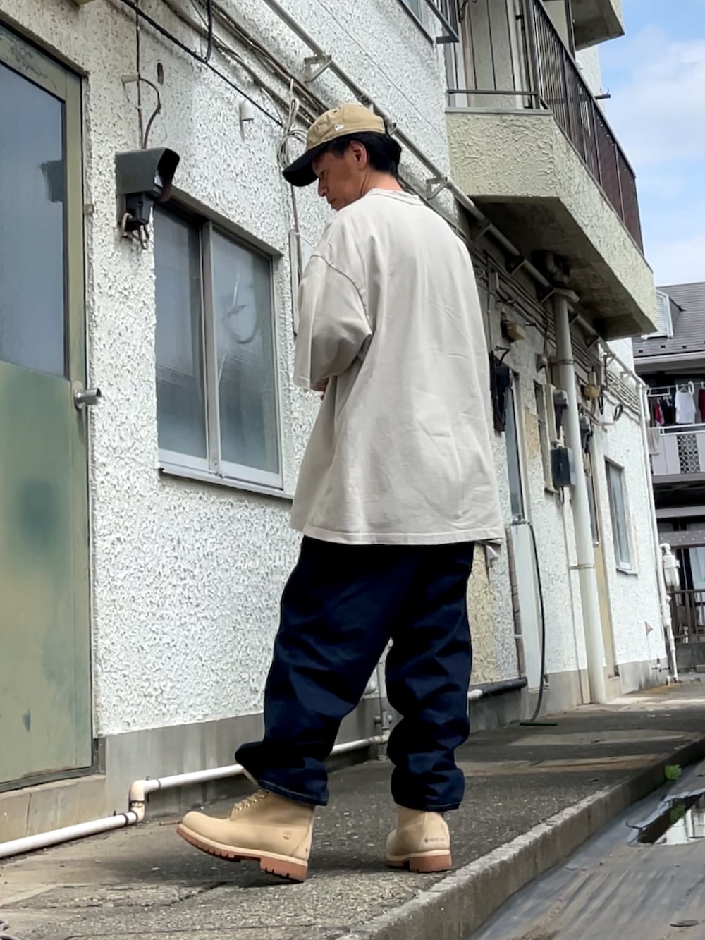 ベージュ系のブーツ、ブルー系のデニムパンツ、グレー系のTシャツ/カットソーを着用したメンズの夏コーディネートの2枚目の写真