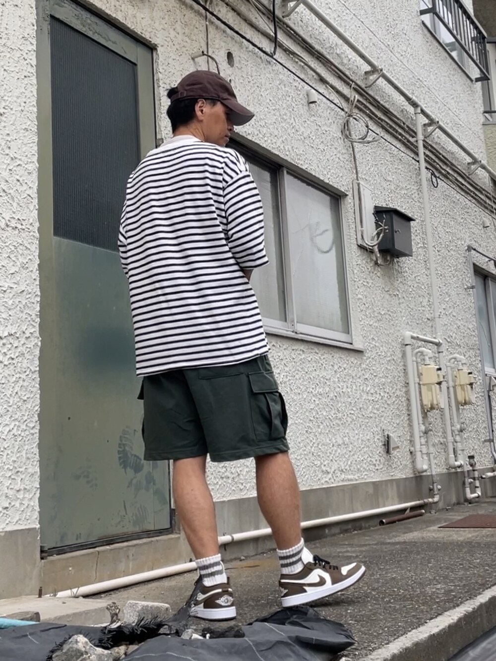 ブラウン系のスニーカー、グリーン系のカーゴパンツ、ホワイト系のTシャツ/カットソーを着用したメンズの秋コーディネートの2枚目の写真