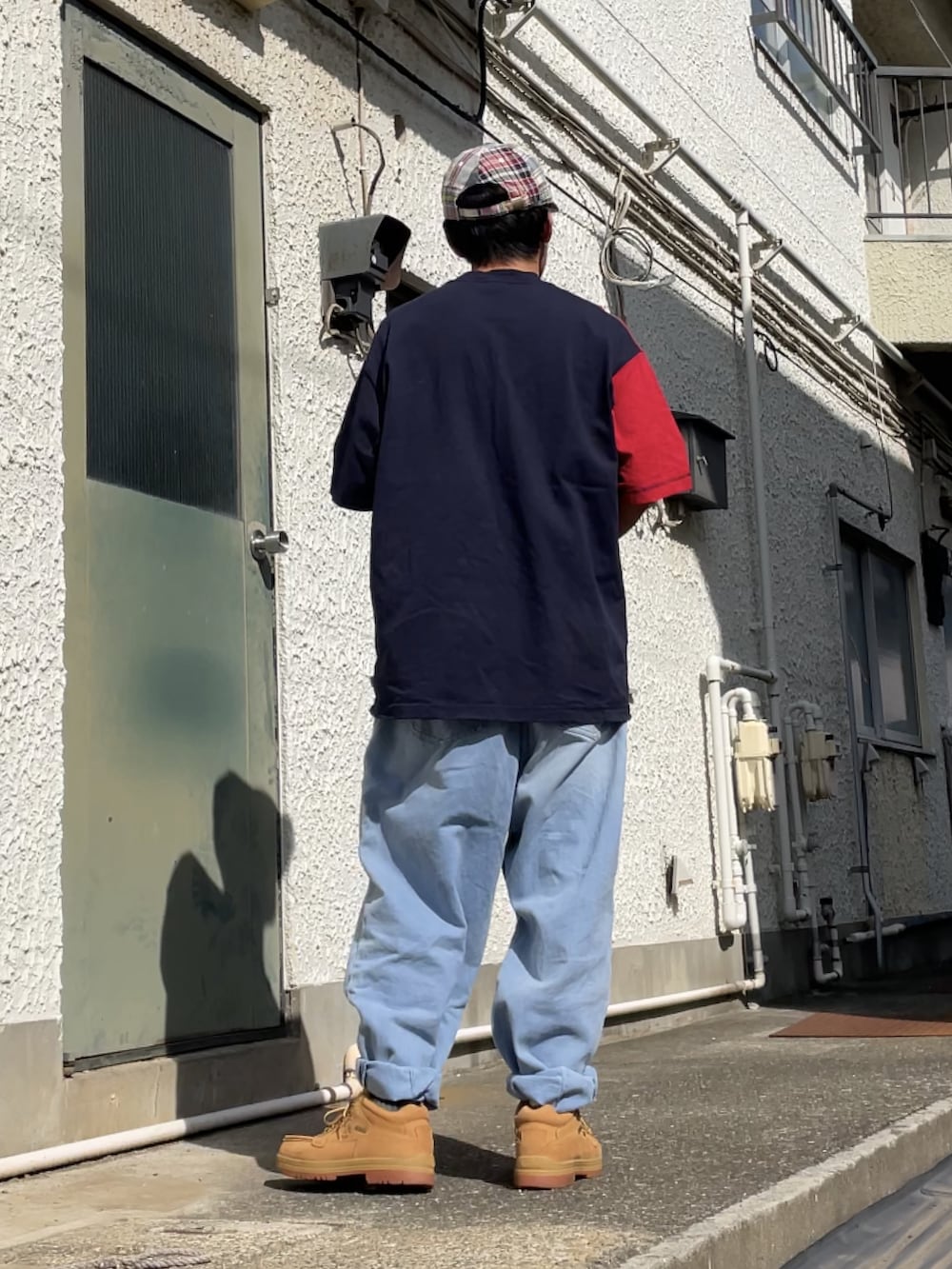 グリーン系のブーツ、ブルー系のデニムパンツ、ブルー系のTシャツ/カットソーを着用したメンズの秋コーディネートの2枚目の写真