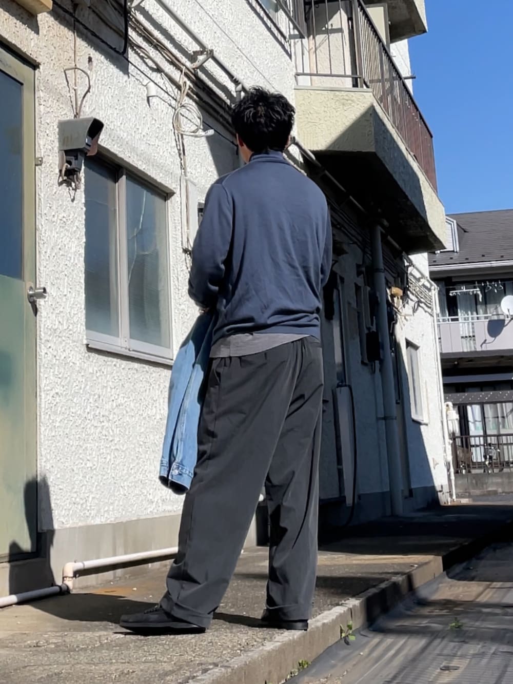 ブルー系のニット/セーター、グレー系のその他パンツ、ブラック系のローファーを着用したメンズの春コーディネートの2枚目の写真