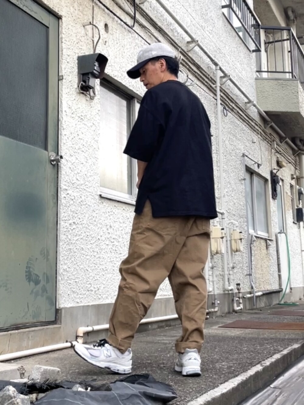 グレー系のスニーカー、ベージュ系のデニムパンツ、ブラック系のTシャツ/カットソーを着用したメンズの秋コーディネートの2枚目の写真