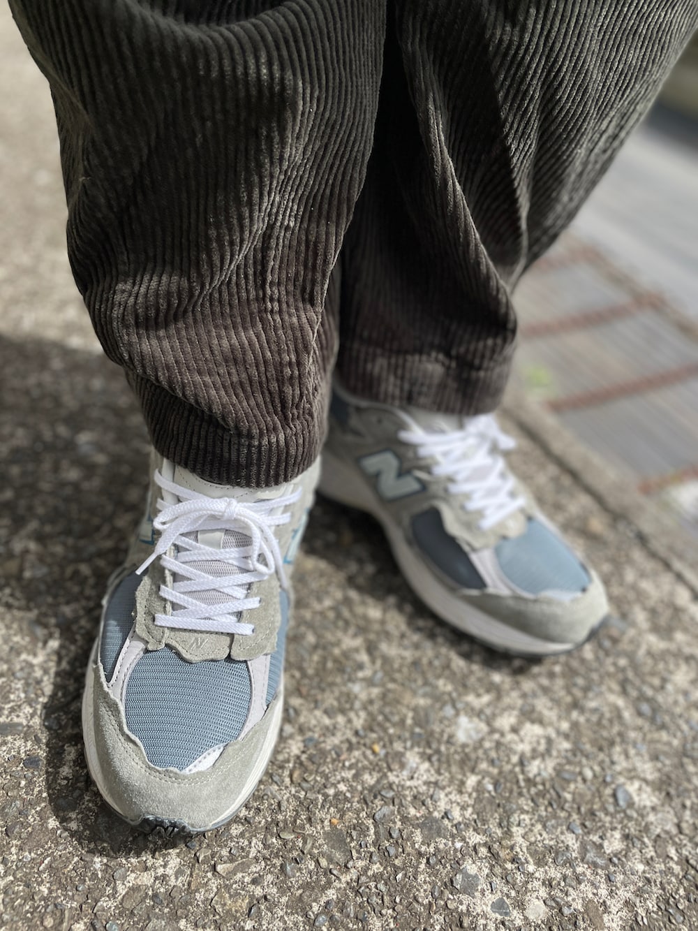 グレー系のスニーカー、グリーン系のその他パンツ、ブルー系のシャツ/ブラウスを着用したメンズの春コーディネートの3枚目の写真