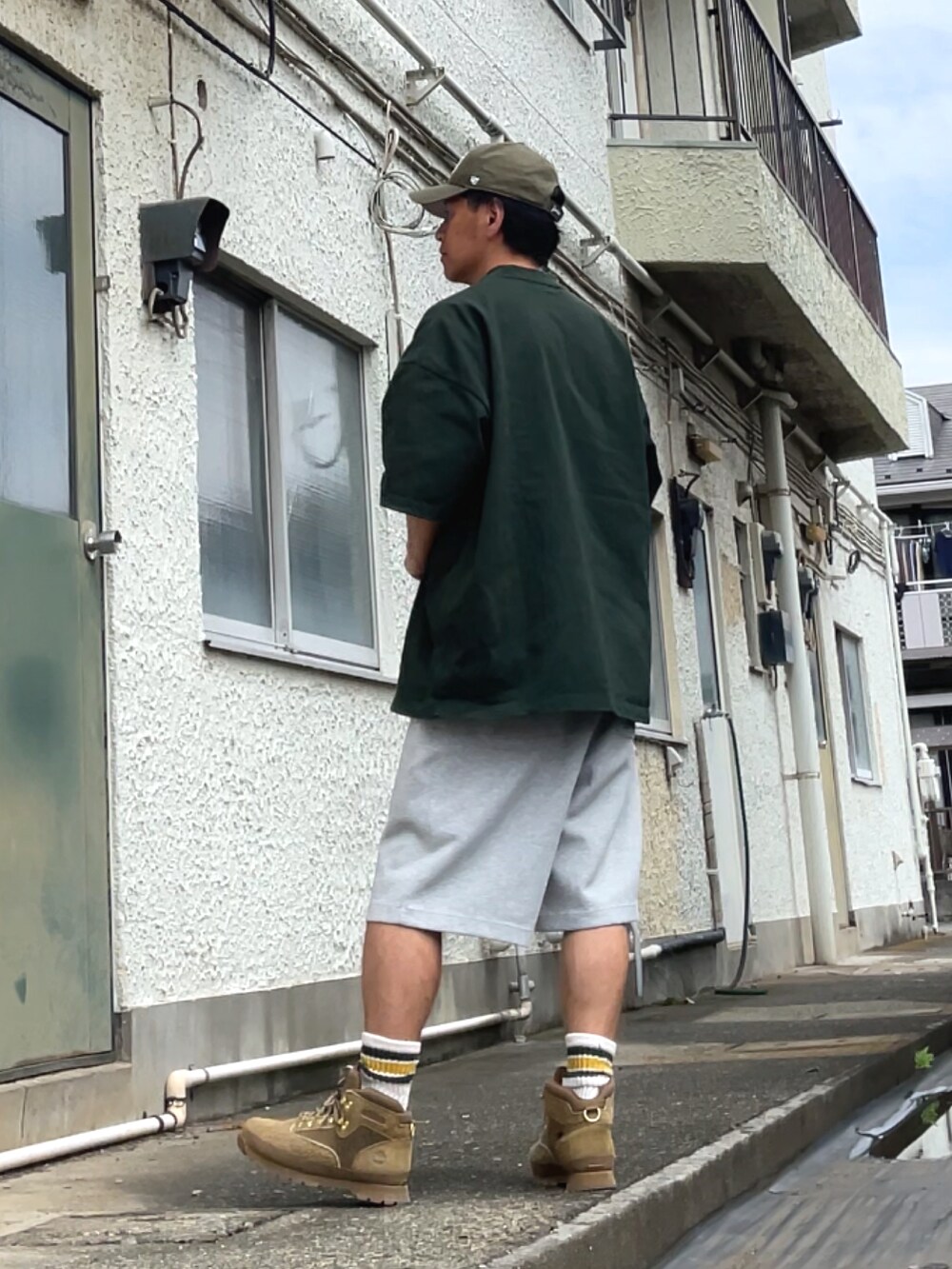 ベージュ系のブーツ、グレー系のスウェットパンツ、グリーン系のTシャツ/カットソーを着用したメンズの夏コーディネートの2枚目の写真
