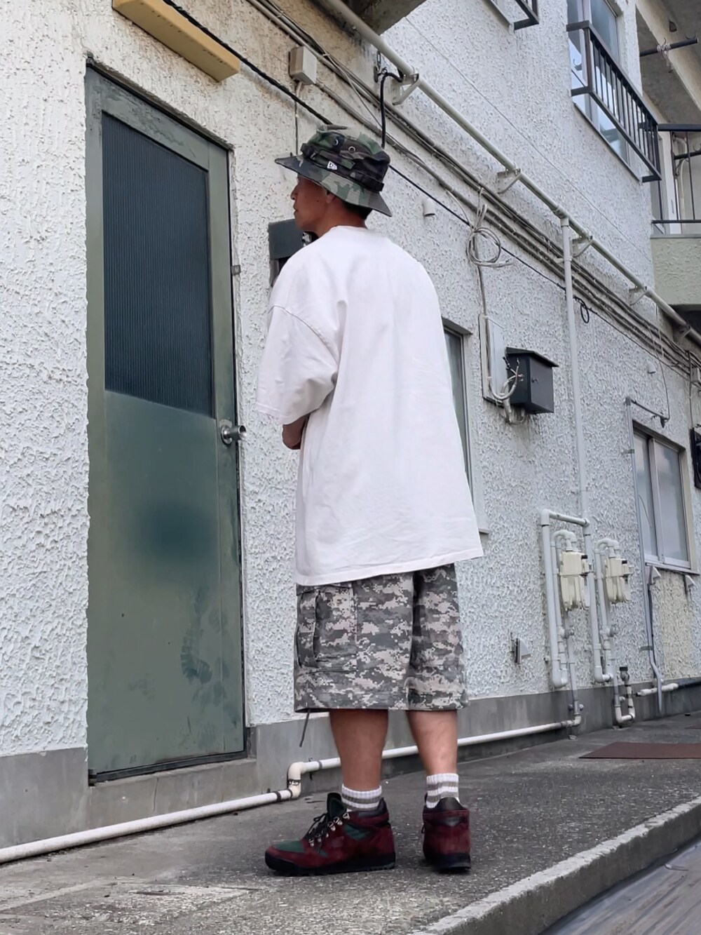 ブラウン系のスニーカー、グリーン系のカーゴパンツ、ベージュ系のTシャツ/カットソーを着用したメンズの夏コーディネートの2枚目の写真