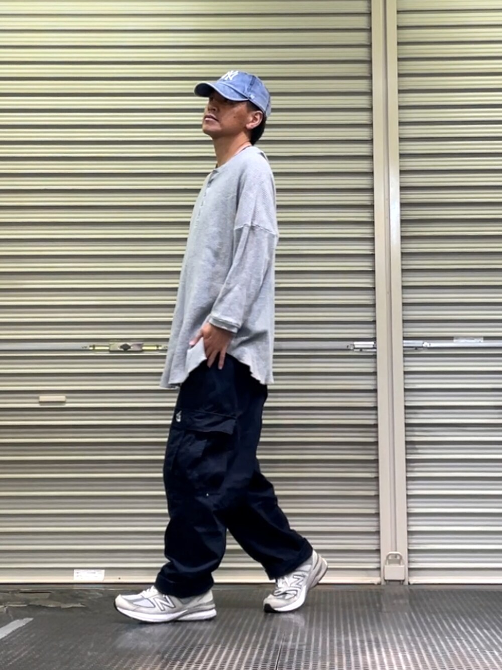 グレー系のスニーカー、ブルー系のカーゴパンツ、グレー系のTシャツ/カットソーを着用したメンズの春コーディネートの2枚目の写真