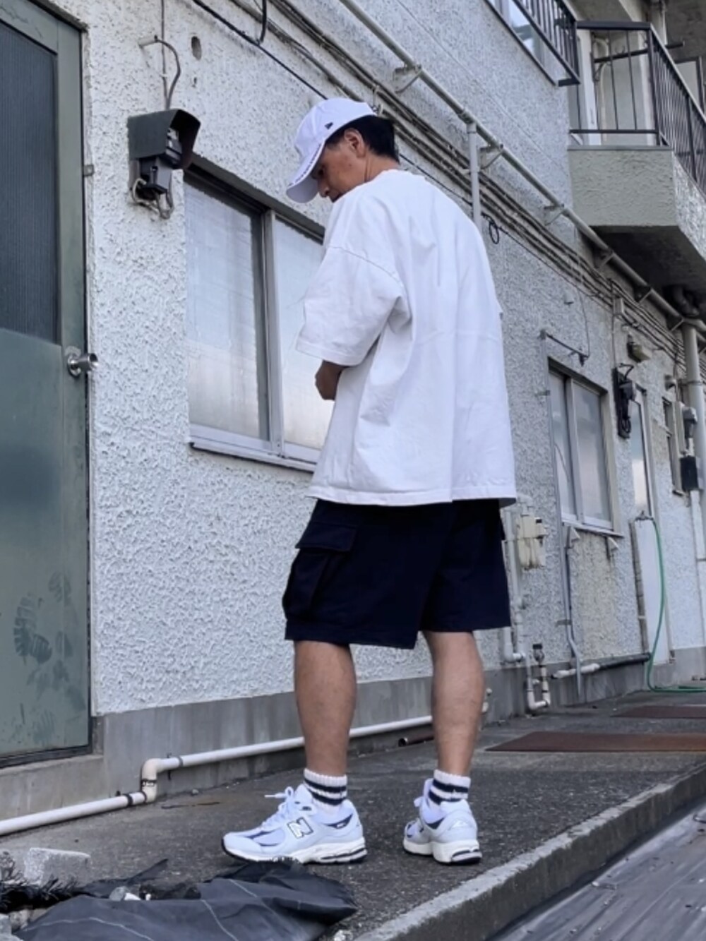 ホワイト系のスニーカー、ブルー系のカーゴパンツ、ホワイト系のTシャツ/カットソーを着用したメンズの秋コーディネートの2枚目の写真